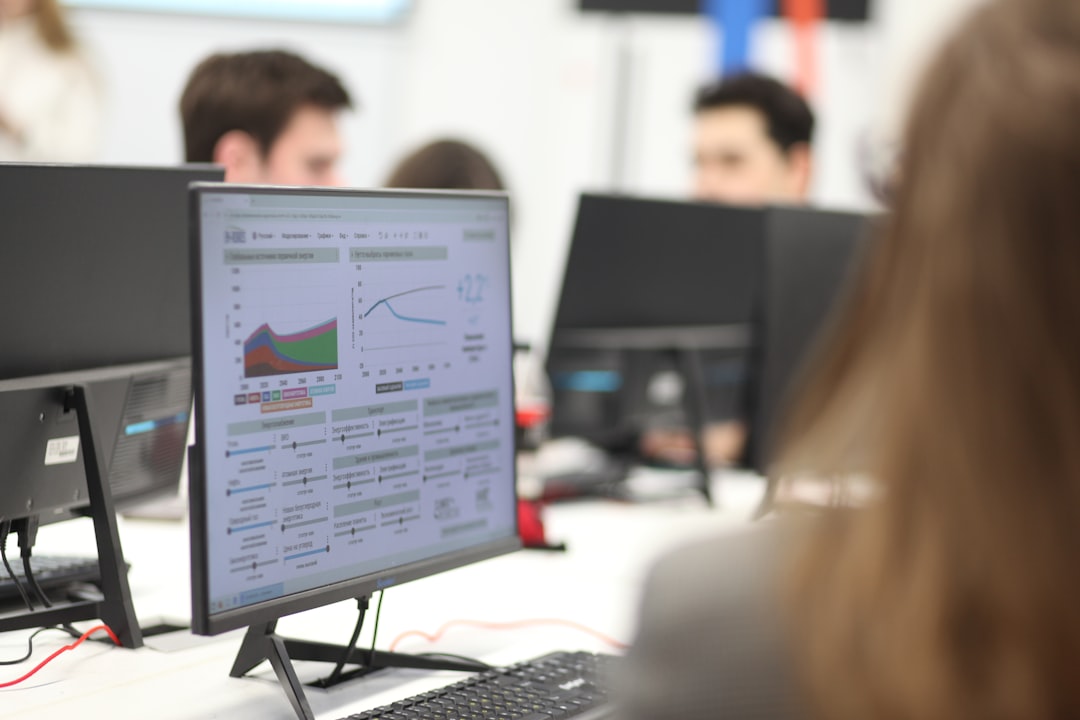 Group of people working together on computers in a modern office, representing an IT or security team