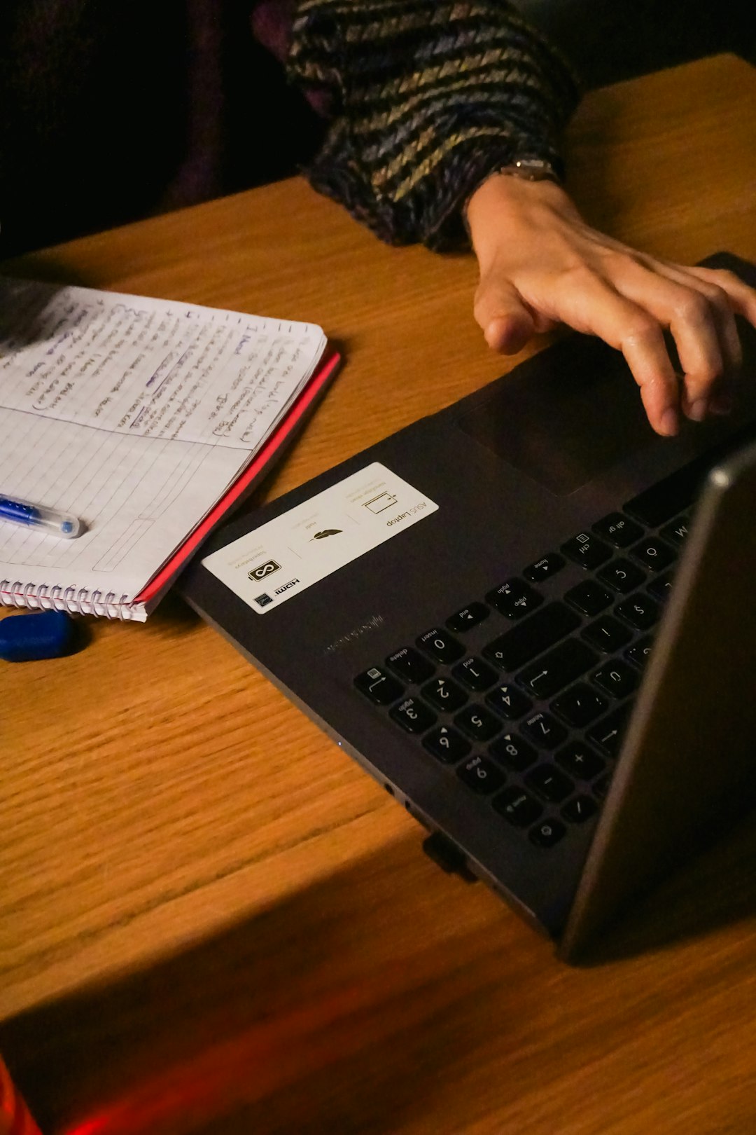Person typing on a laptop at a wooden table, representing working productively with AI tools