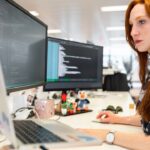 Woman working at a computer, representing a cybersecurity analyst at her desk