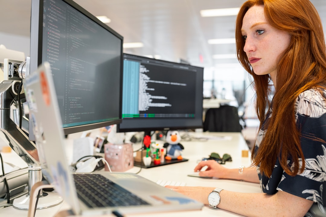 Woman working at a computer, representing a cybersecurity analyst at her desk